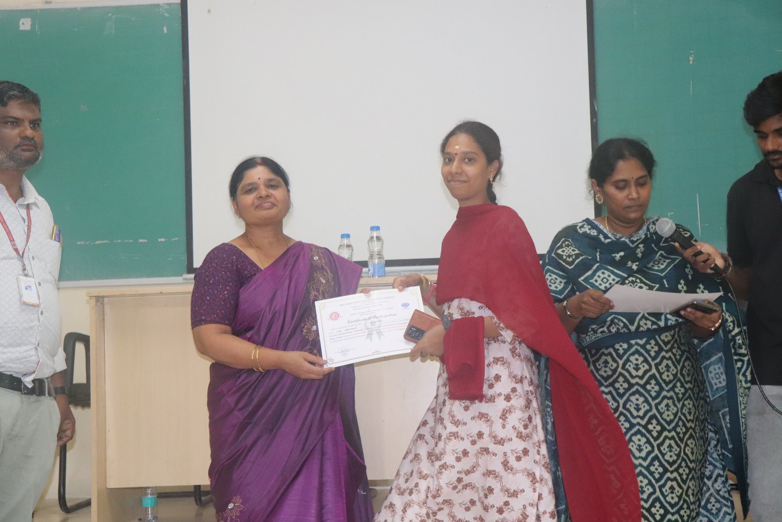 A HITS faculty member receiving a certificate at a development programme